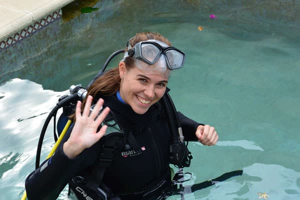 Chica feliz por realizar un bautismo de buceo