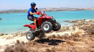 Man riding a quad bike round a lake