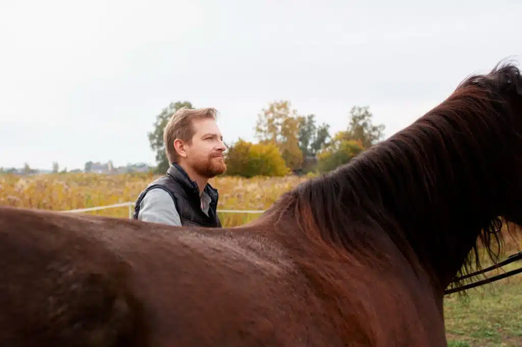 Un chico sonriendo con su caballo y puede montar a caballo con su hernia discal