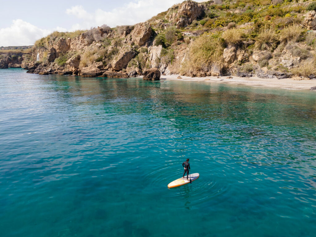 Persona haciendo paddle surf en la isla de Tabarca