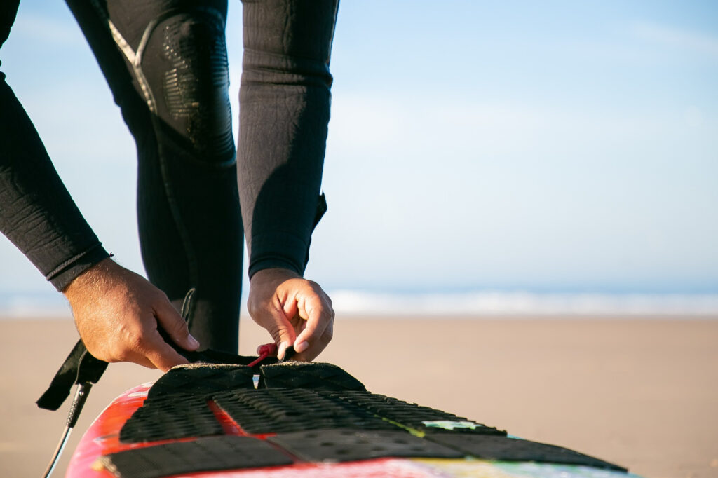 hombre ajustando la tabla de paddle surf