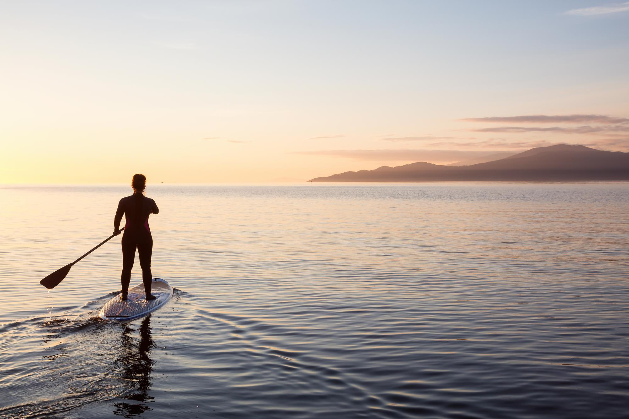 persona haciendo paddle surf