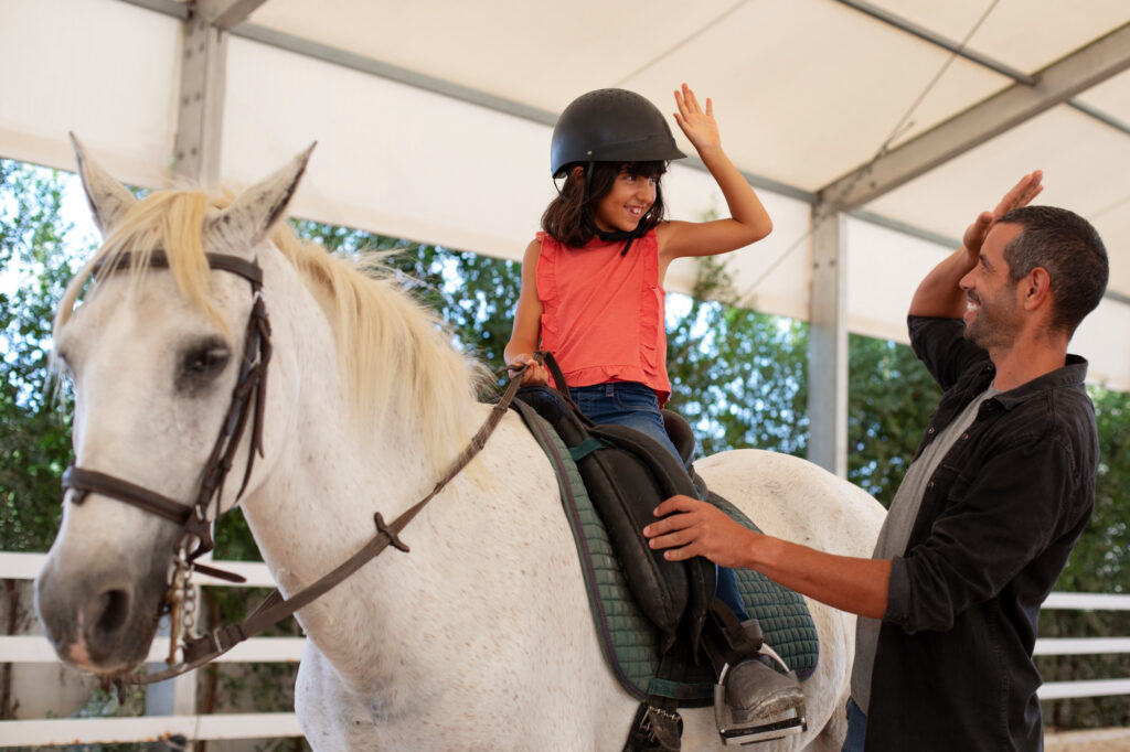 niña aprendiendo a montar a caballo en Alicante